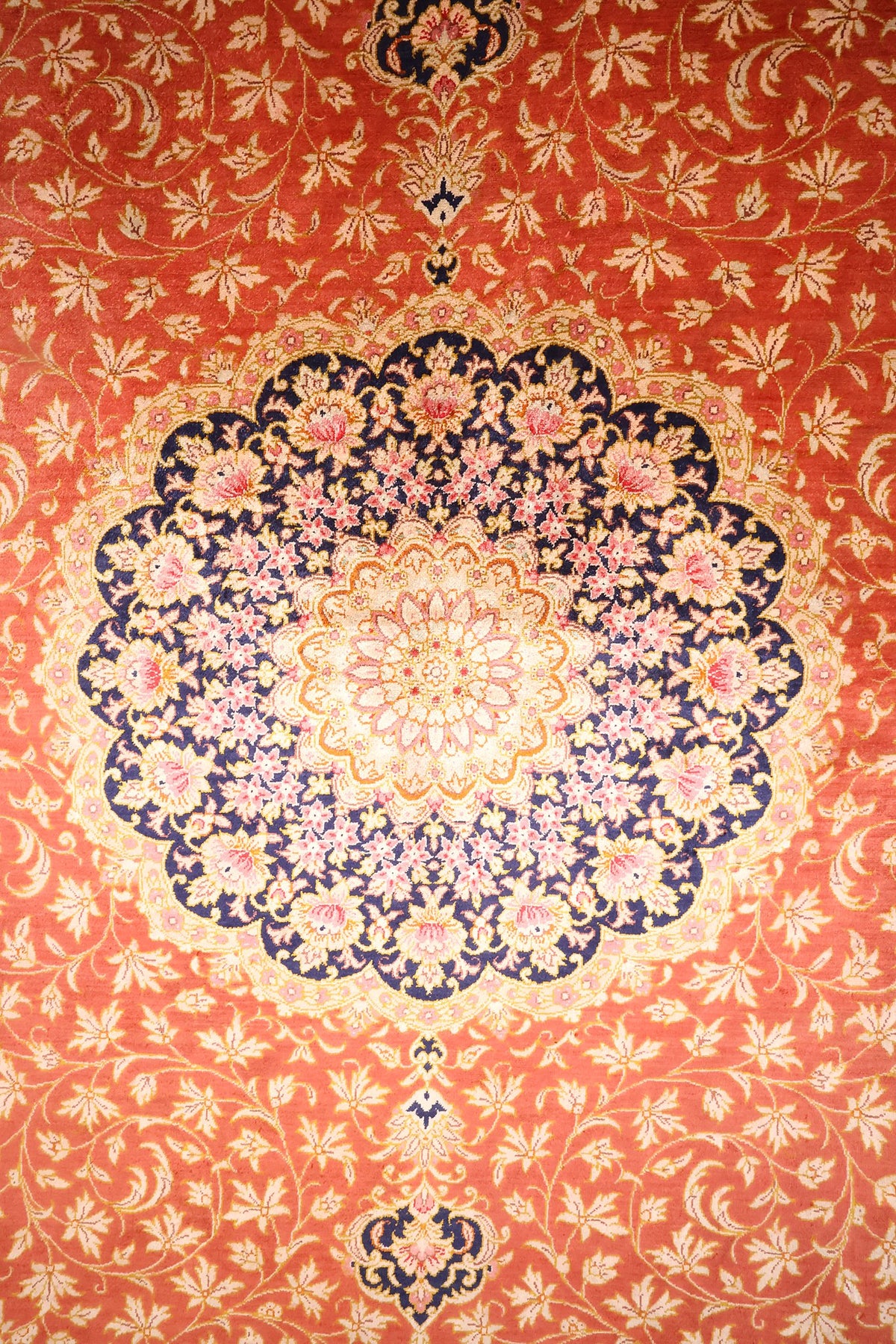 Détail du médaillon lobé bleu nuit à rosace ivoire et fleurs roses du tapis Ghoum