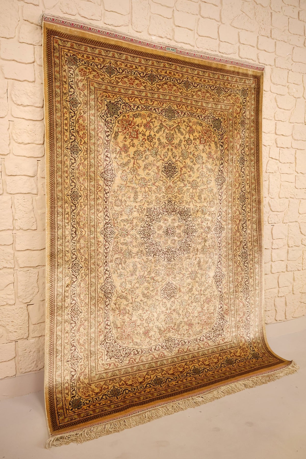 Tapis Ghoum beige et jaune doré en soie, vue de biais montrant l'encadrement fleuri