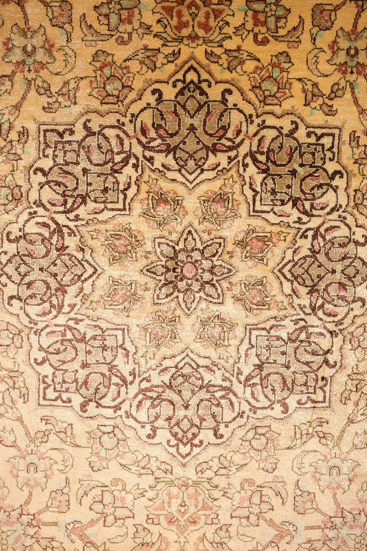 Détail du médaillon étoilé brun et des rinceaux fleuris du tapis Ghoum beige