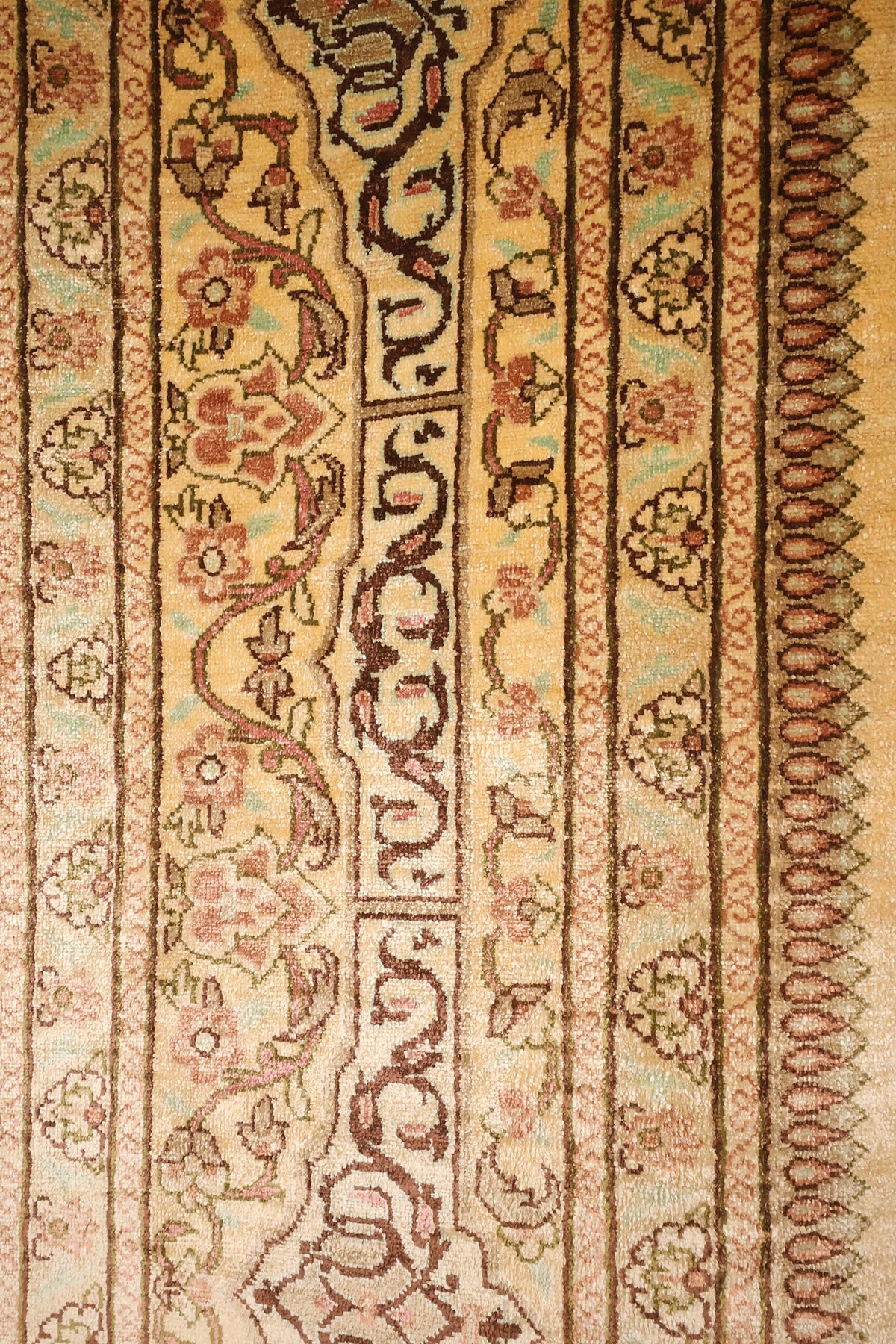 Bordure principale à volutes et frises fleuries du tapis Ghoum, tons jaune et brun