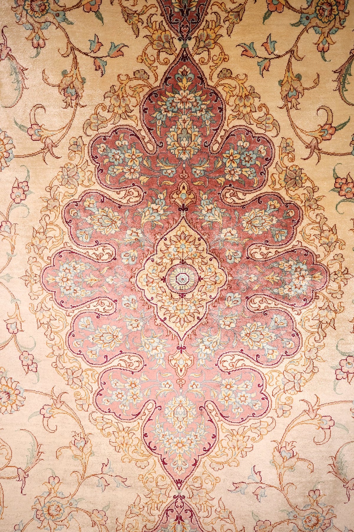Détail du médaillon polylobé rose saumon à cœur ivoire du tapis Ghoum