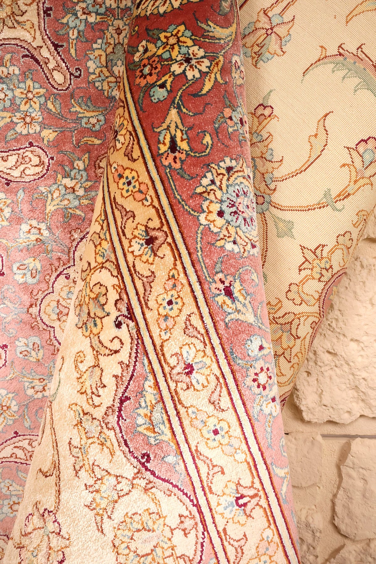 Tapis Ghoum beige et rose replié, envers et bordure fleurie en vis-à-vis