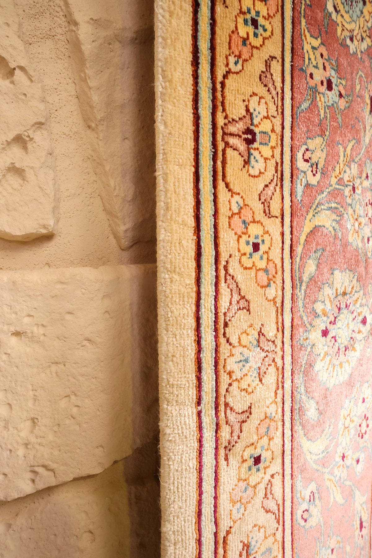 Lisière du tapis Ghoum en soie, fine bordure beige et champ rose