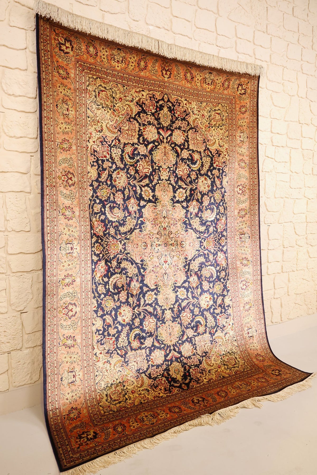 Tapis Ghoum bleu et orange vu de biais, champ fleuri et bordure saumon