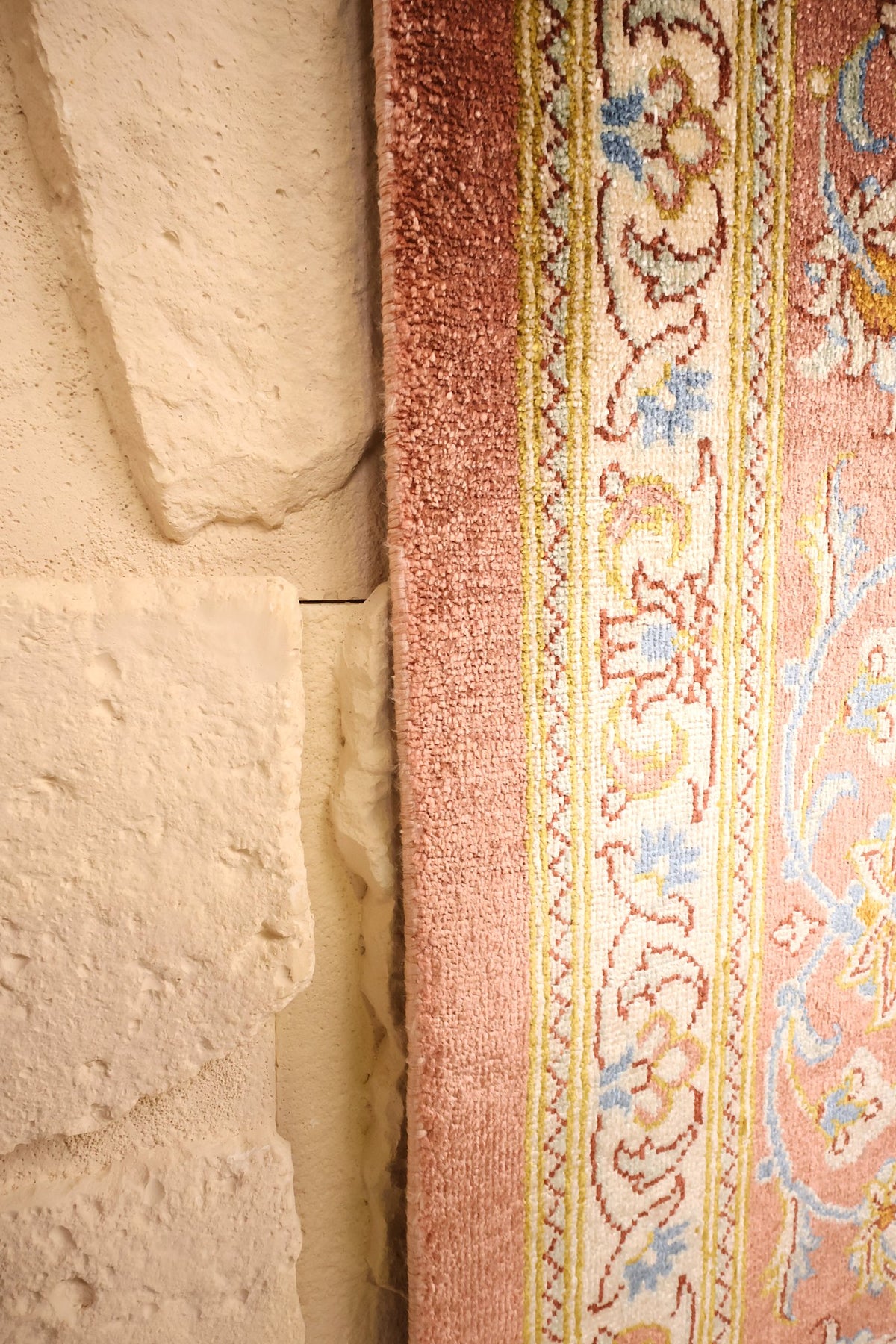 Lisière rose du tapis Ghoum en soie, le long des contre-bordures ivoire