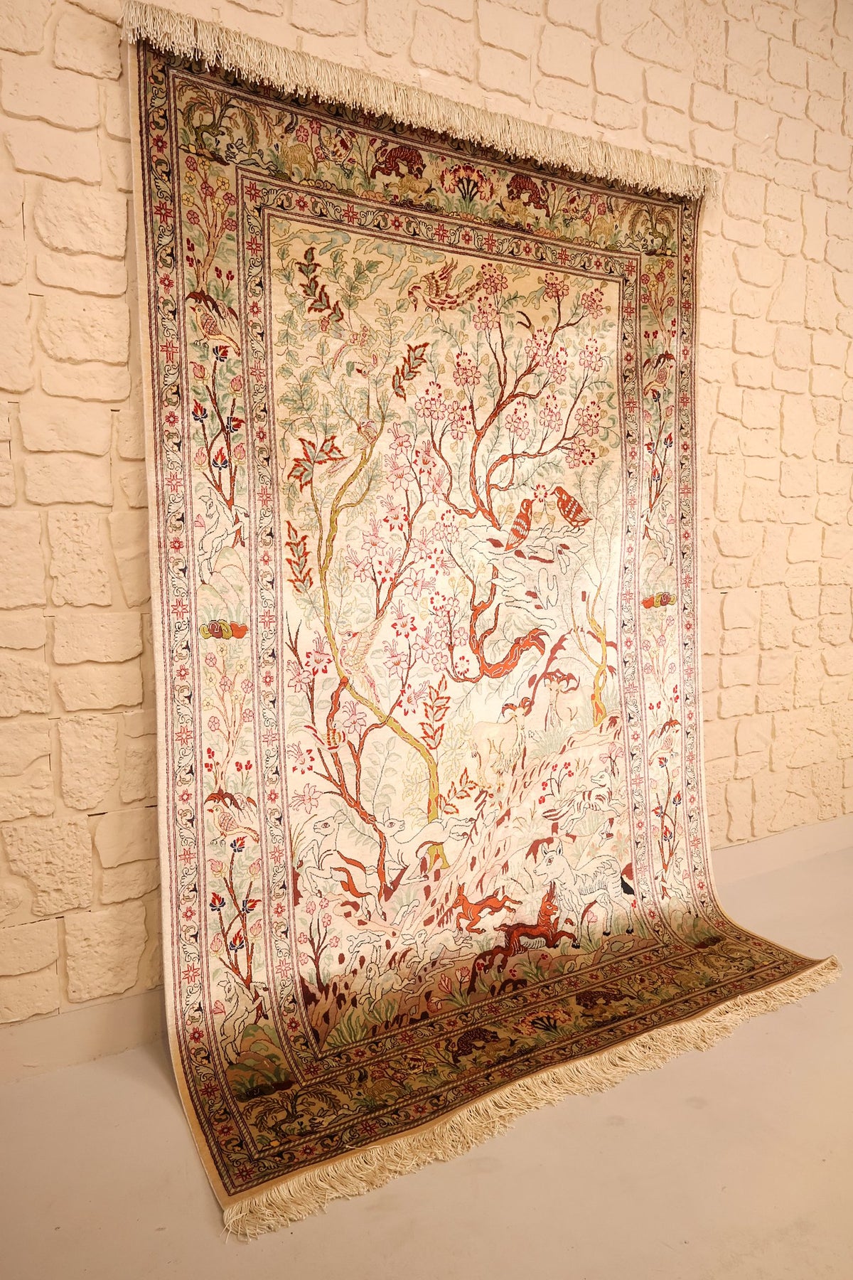 Tapis Ghoum beige en soie vu de biais, franges ivoire et bordure fleurie