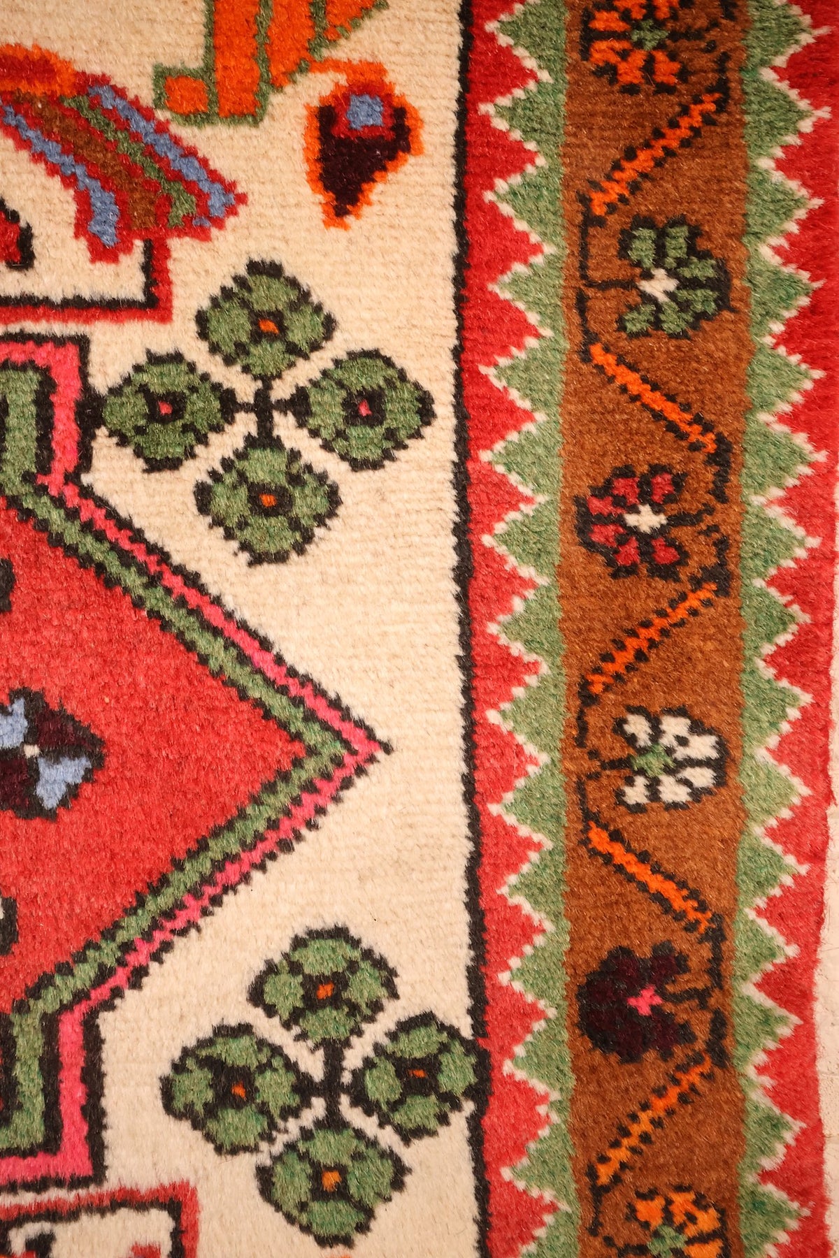 Bordure brune à fleurs stylisées et contre-bordures vertes et rouges à dents de scie