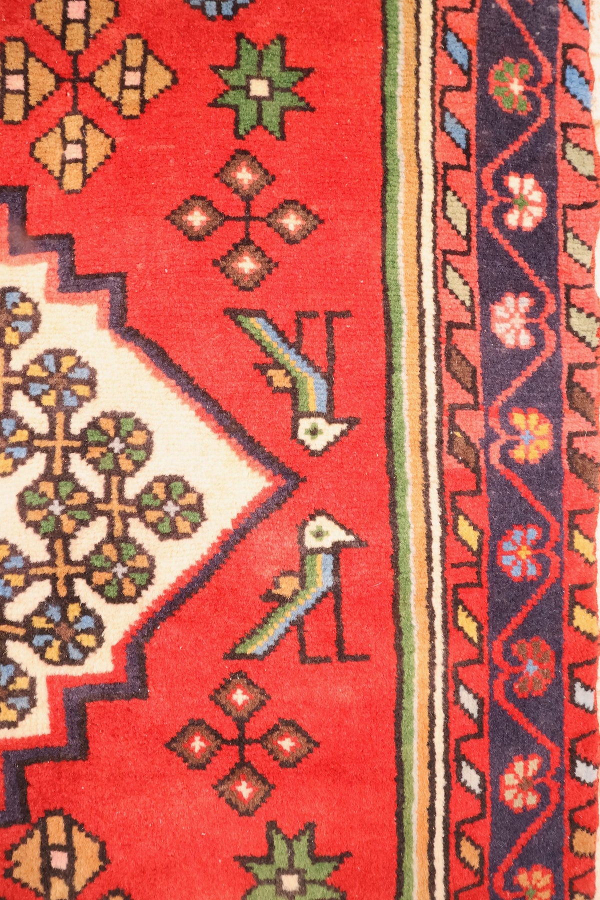 Bordure bleu nuit à guirlande de fleurs et oiseaux stylisés du tapis Hamadan