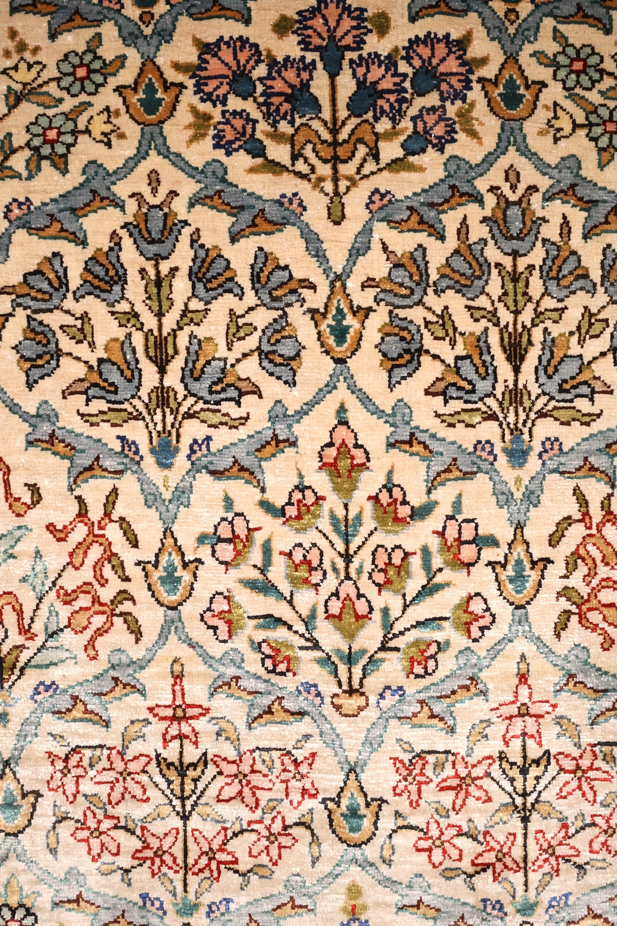 Détail du semis de bouquets et arcades de rinceaux bleu clair sur champ beige