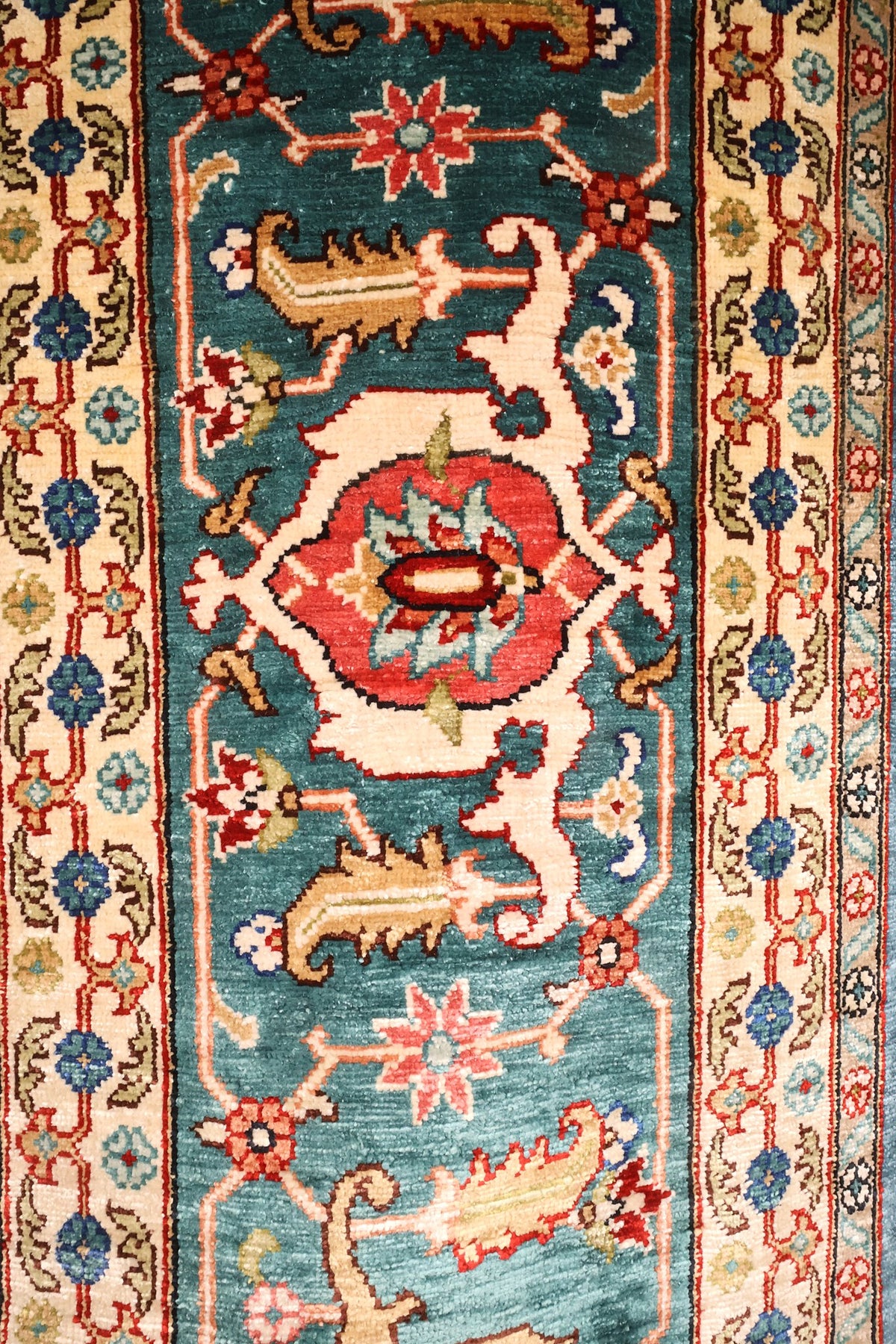 Bordure principale à cartouches rouges et contre-bordures beiges fleuries, tapis Hereke