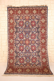Tapis Hereke bleu et rouge 188 × 113 cm, vue d'ensemble avec franges claires