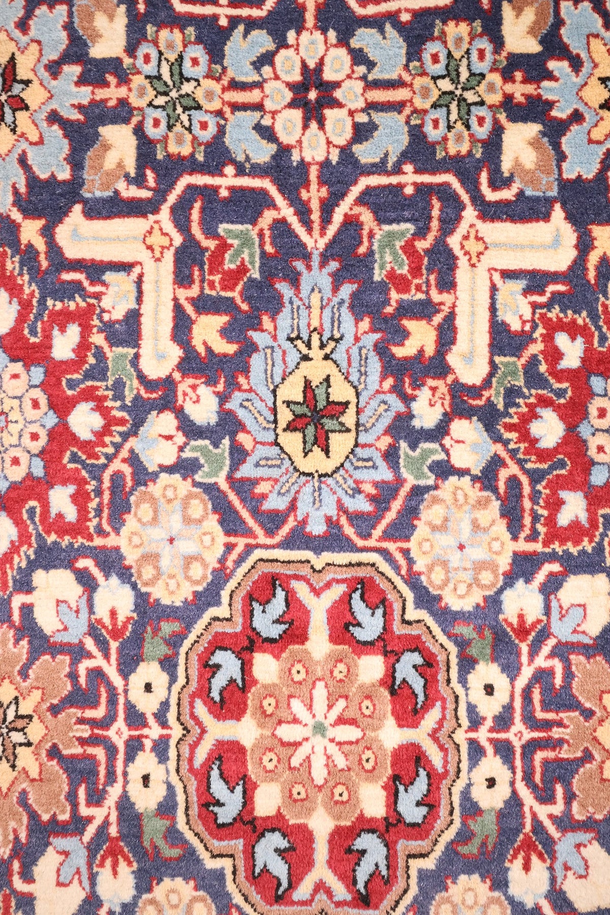 Détail du semis de palmettes et rosaces rouges sur champ bleu nuit, tapis Hereke