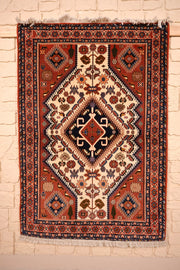 Tapis Heriz rouge 145 × 100 cm, vue d'ensemble du médaillon losangé bleu nuit sur champ ivoire