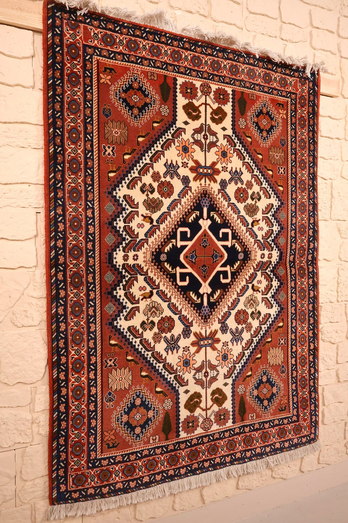 Tapis Heriz rectangulaire en laine, vue de biais avec ses franges blanches
