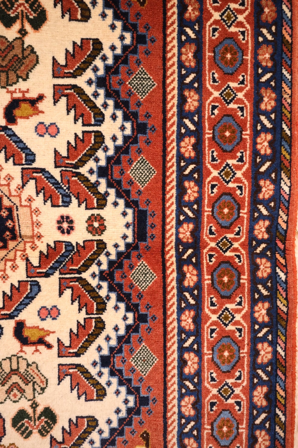 Bordure rouge à rosettes et cartouches bleus du tapis Heriz, contre-bordures étroites