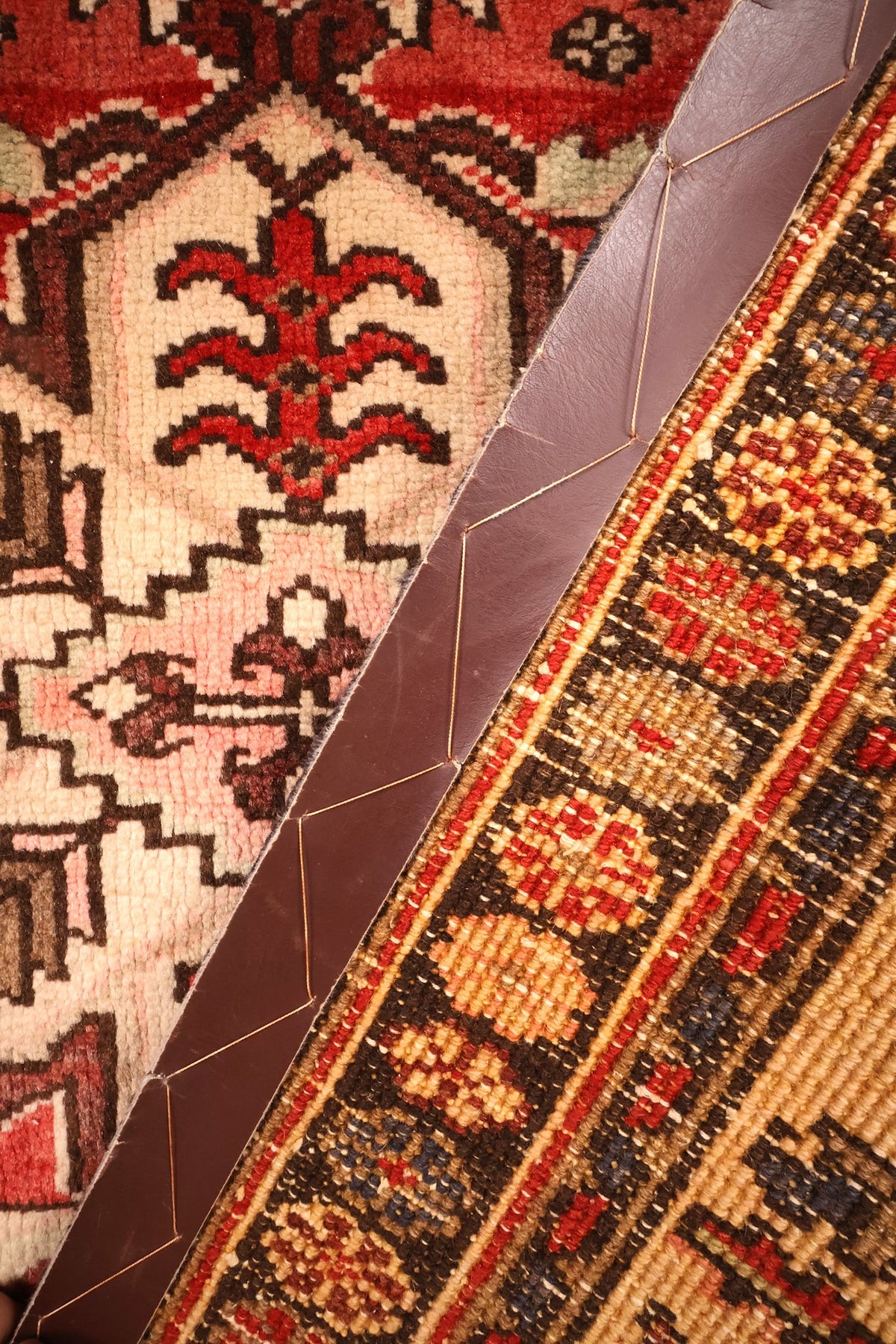 Envers du tapis Heriz noué à la main, nœuds de laine visibles sur coin replié