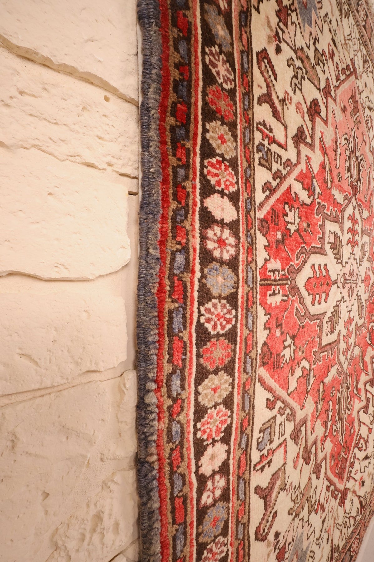 Bord latéral du tapis Heriz rouge et marron, rosettes alignées le long de la lisière
