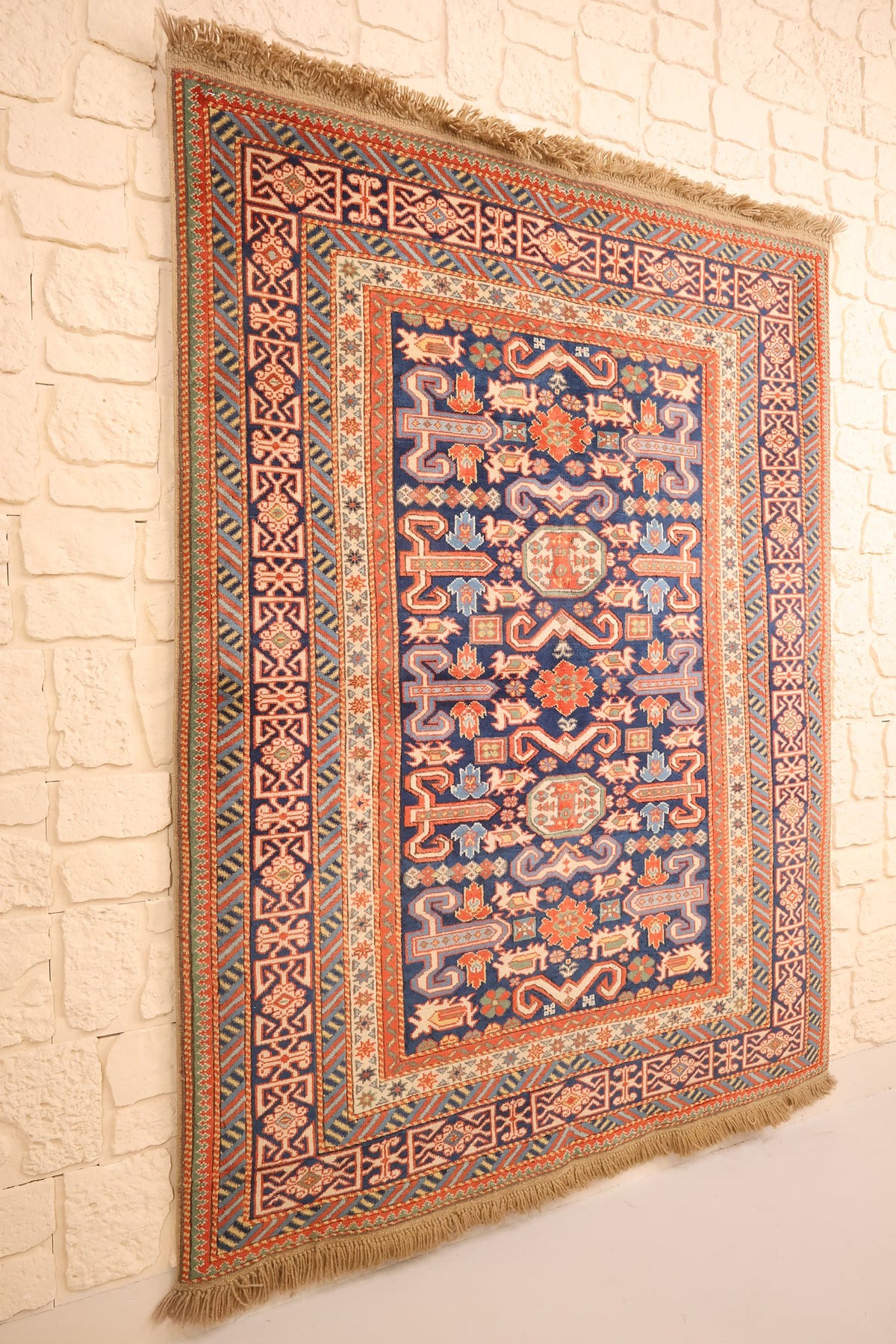 Tapis Hitit rectangulaire à champ bleu, vue de biais montrant les bordures multiples