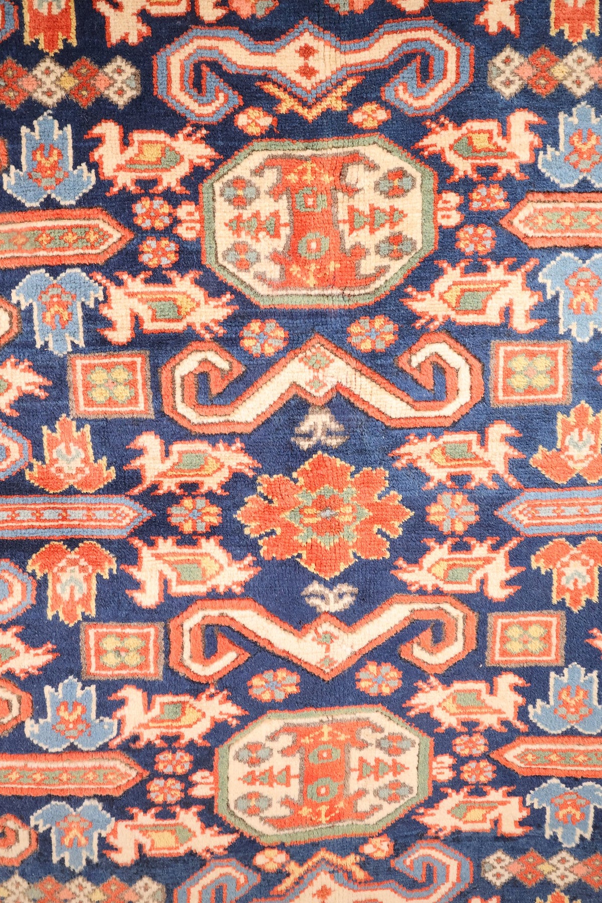 Détail du champ bleu : rosettes orange, crochets en S et médaillon octogonal ivoire