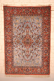 Tapis Ispahan rouge et gris en laine, champ gris-bleu à médaillon central, vue de face