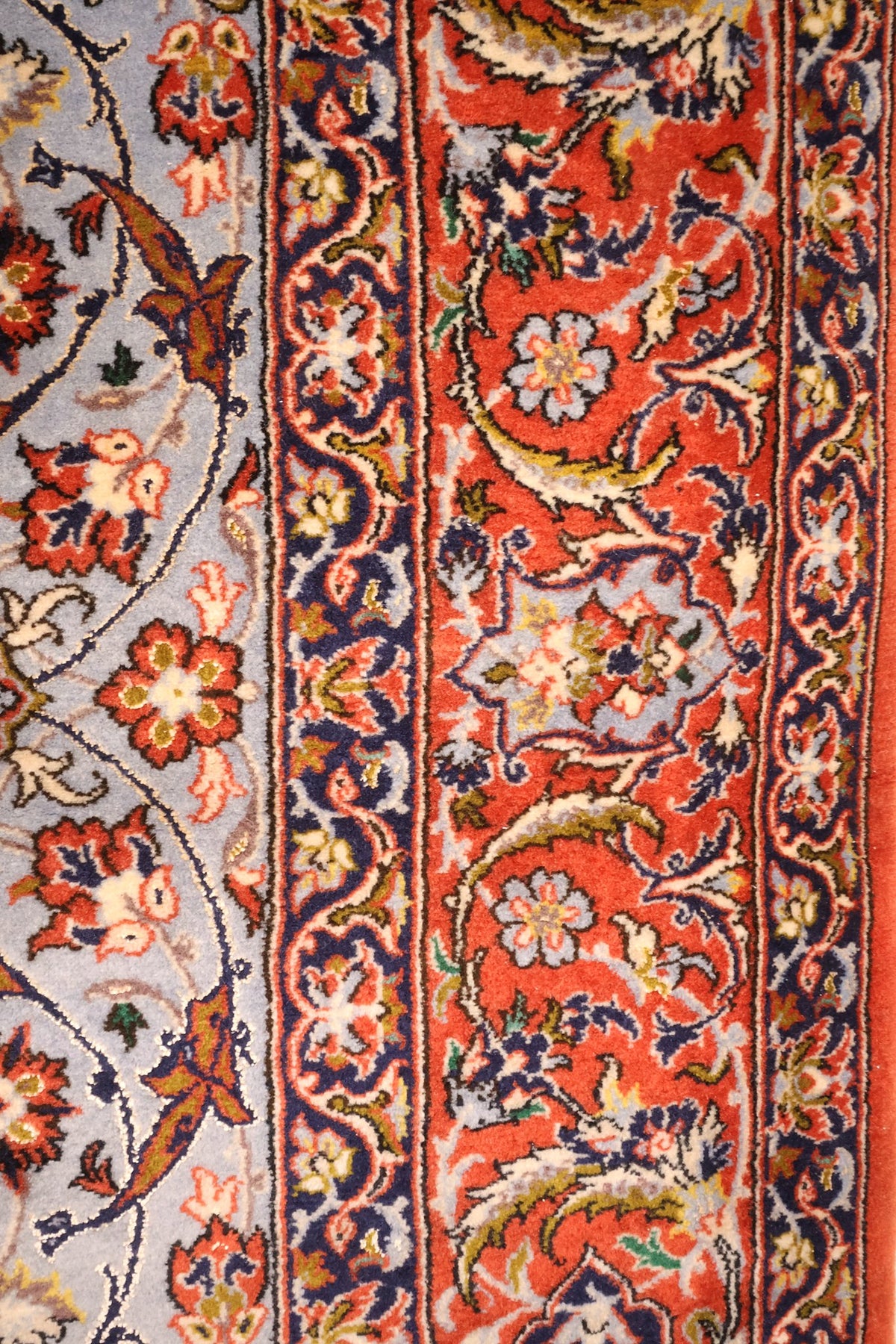 Bordure rouge à rinceaux fleuris et contre-bordures bleu foncé du tapis Ispahan