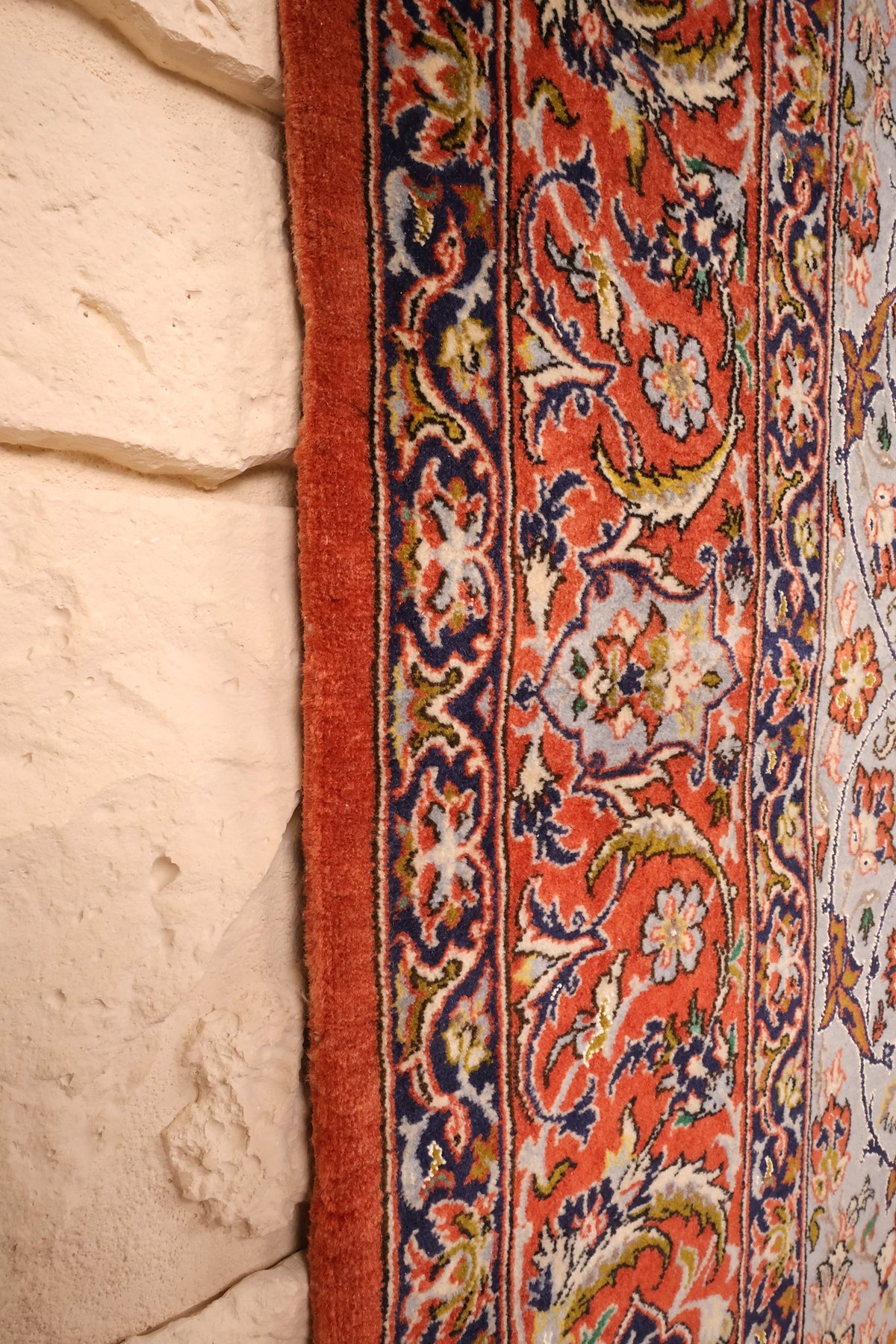Lisière rouge du tapis Ispahan et contre-bordure bleu foncé le long du champ