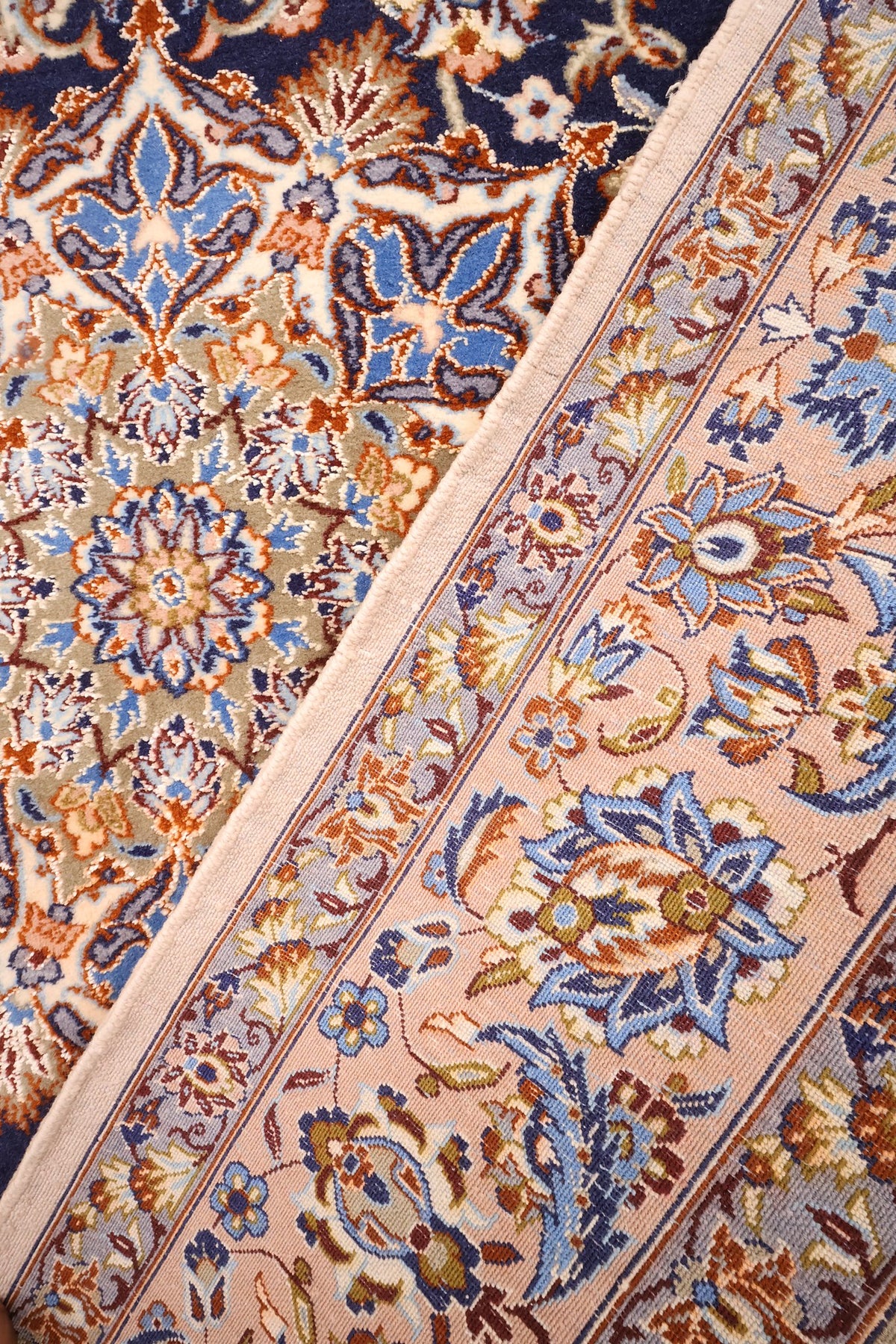 Coin replié du tapis Ispahan beige et orange, rinceaux fleuris et lisière