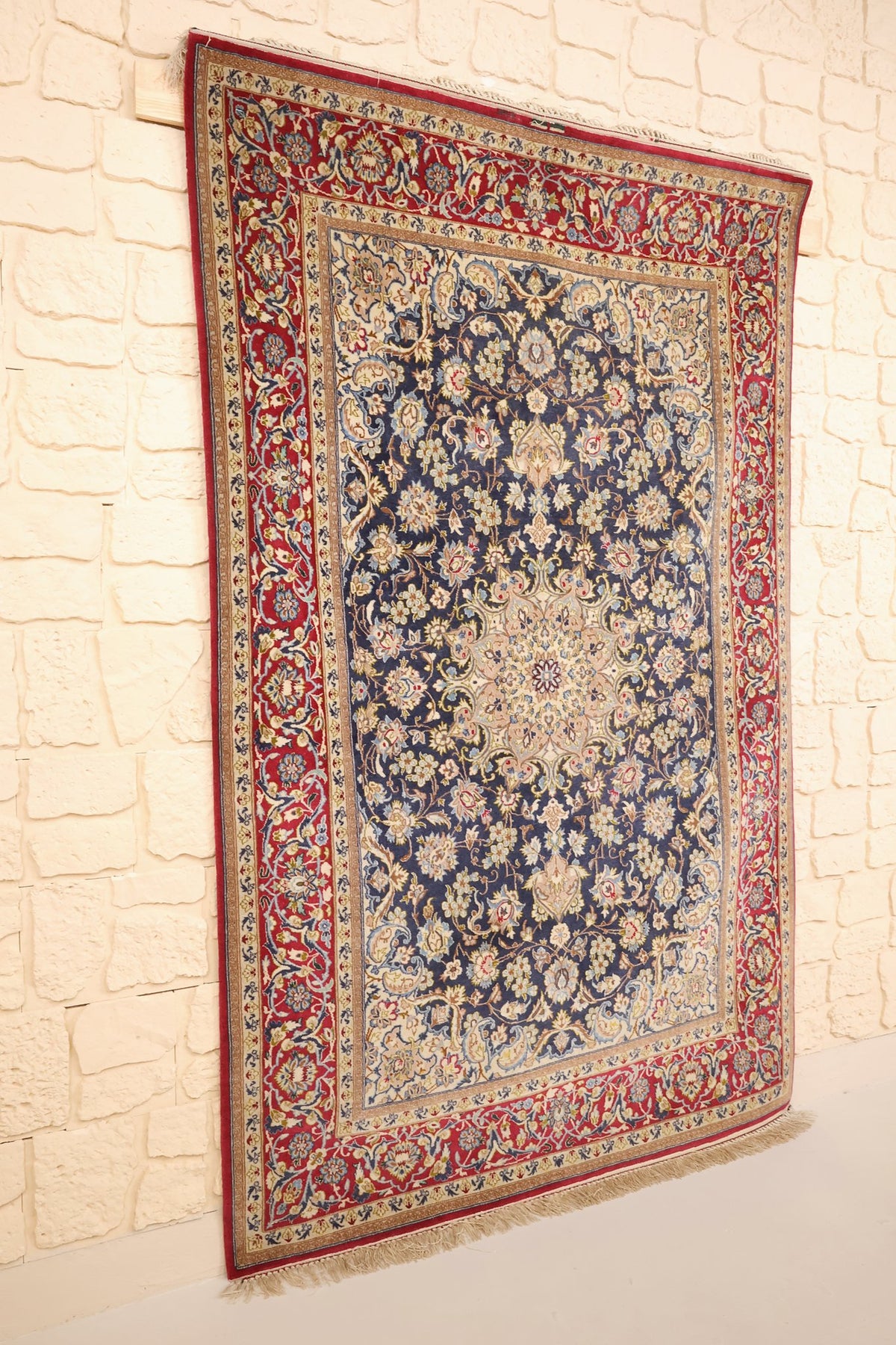 Tapis Ispahan en laine noué main, vue de biais montrant la bordure rouge