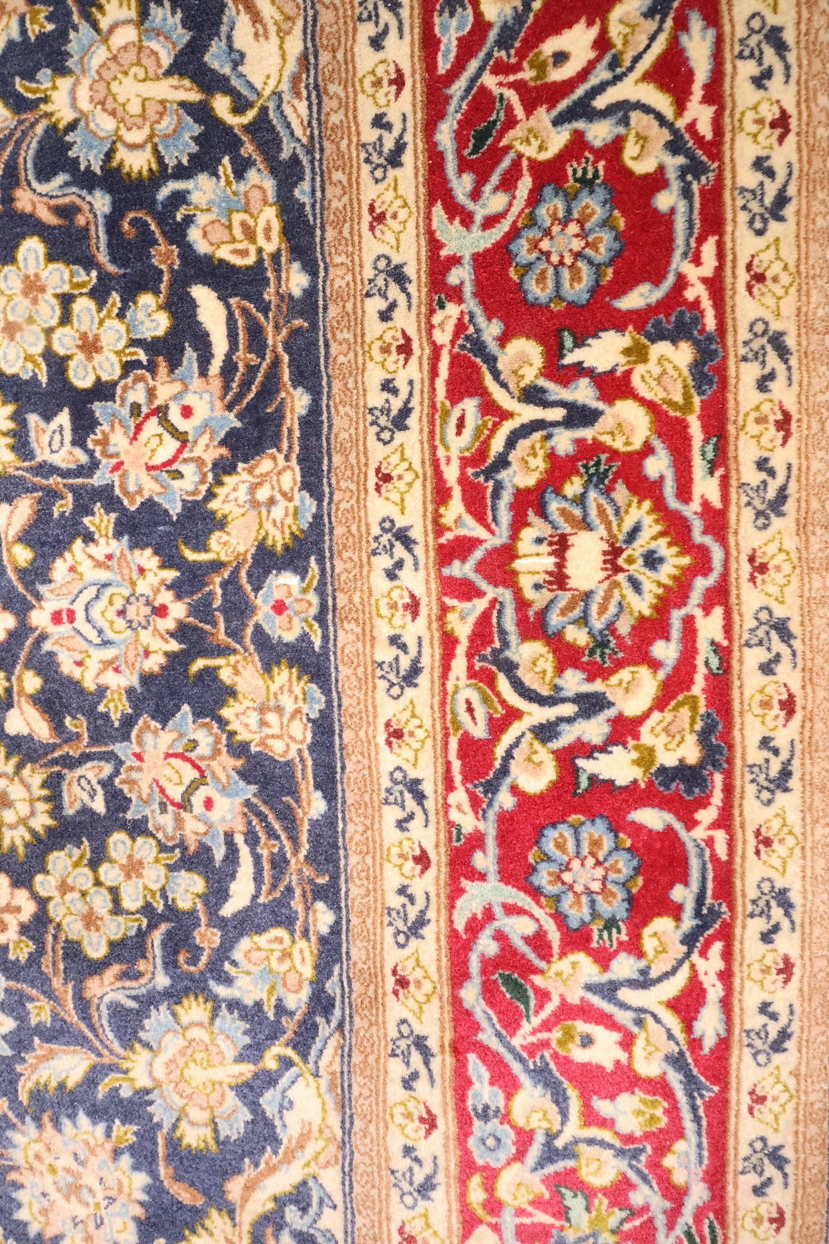 Bordure rouge à rinceaux fleuris et contre-bordures ivoire du tapis Ispahan