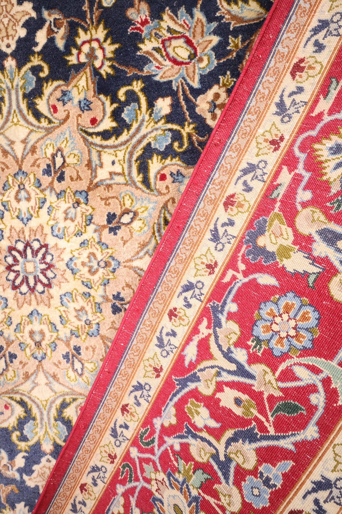 Coin replié du tapis Ispahan, pendentif ivoire et bordure rouge en laine