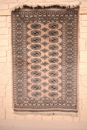 Tapis Karachi beige 143 × 91 cm, vue d'ensemble avec ses gols noirs et franges blanches