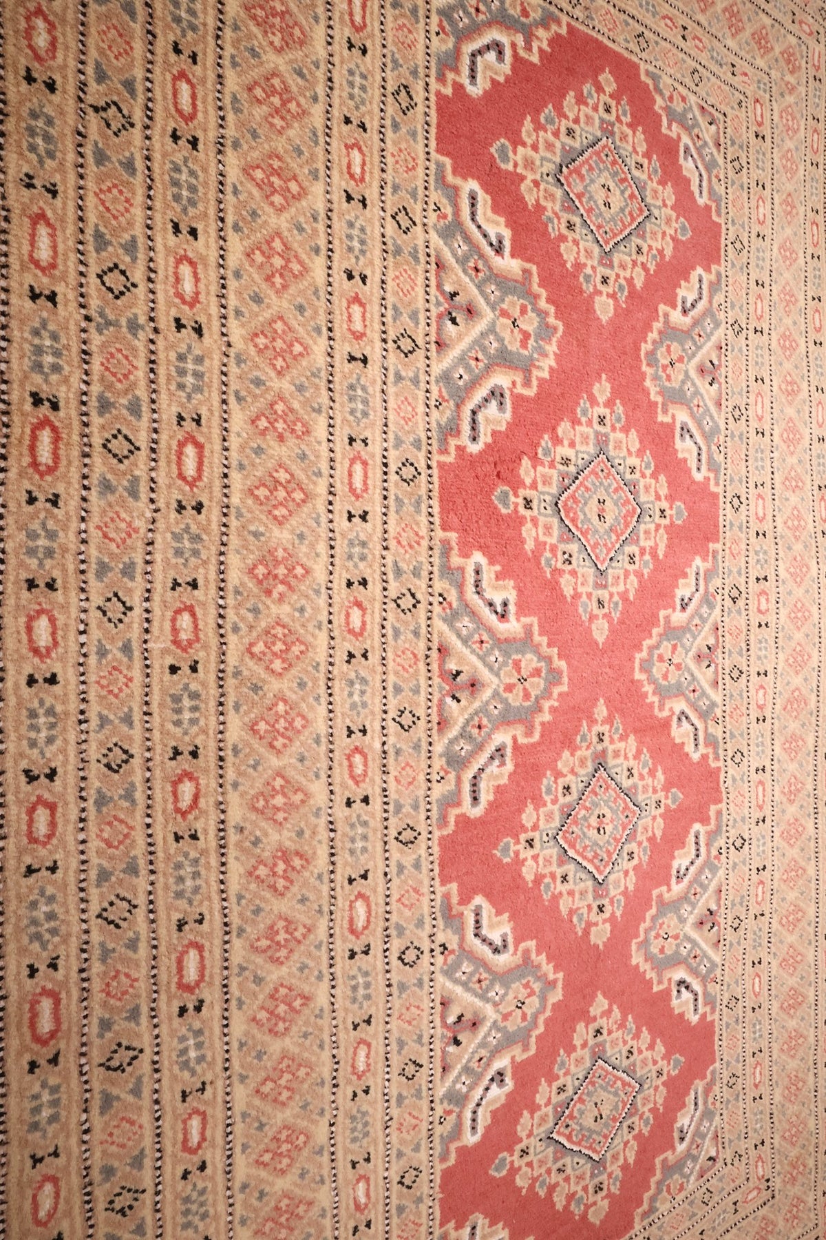 Colonne de médaillons et succession de bordures du tapis Karachi rose