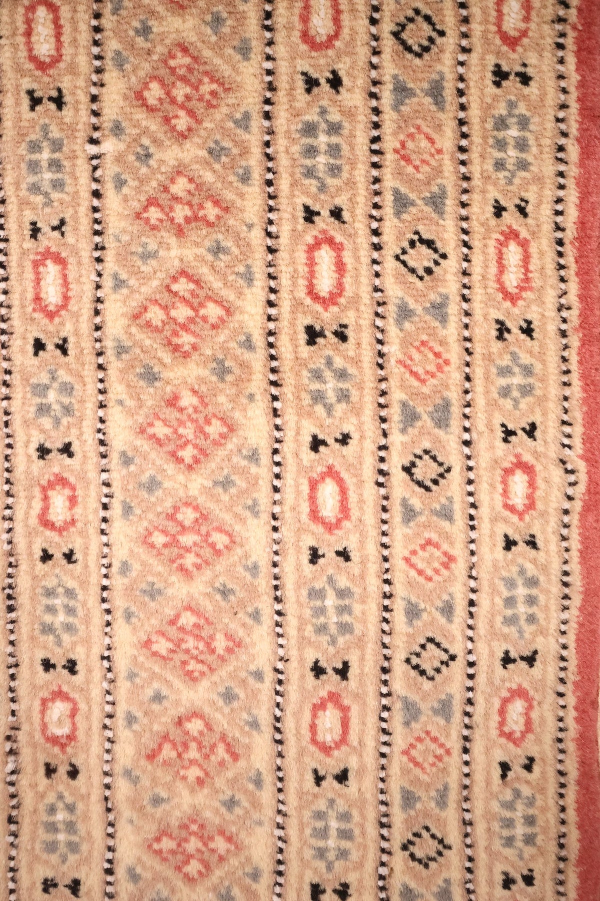 Bordures beige à rosaces et losanges du tapis Karachi, fines rayures noir et blanc