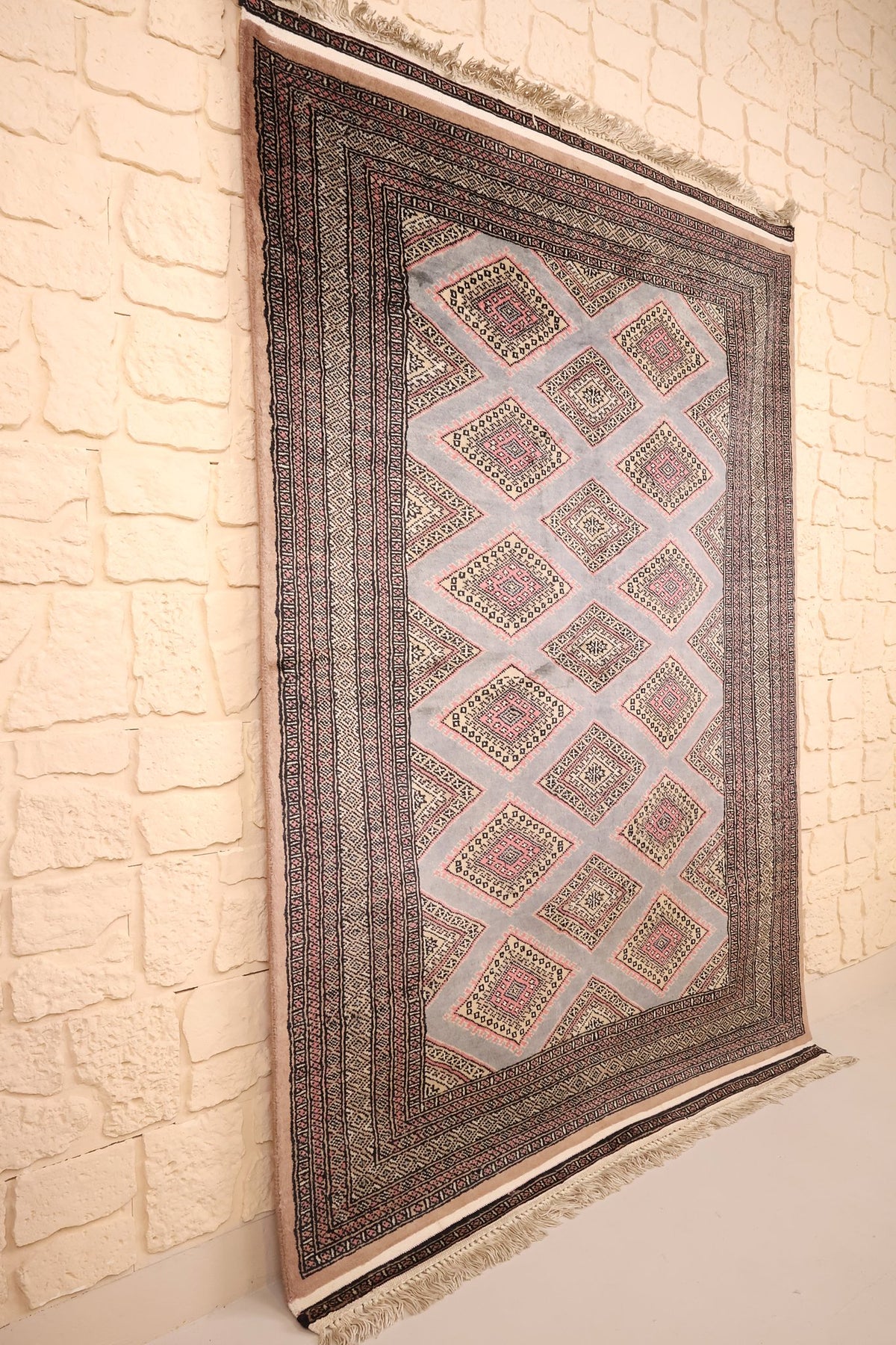 Tapis Boukhara en laine noué main, vue de biais montrant les bordures étroites