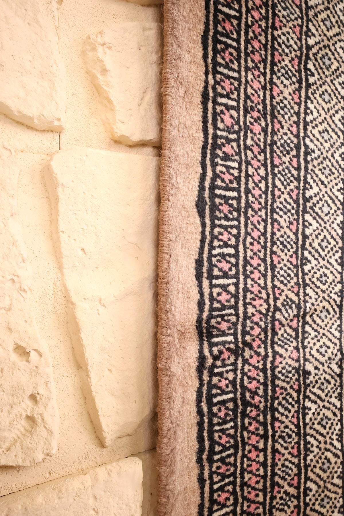 Lisière du tapis Boukhara gris et rose, encadrement beige vu de près