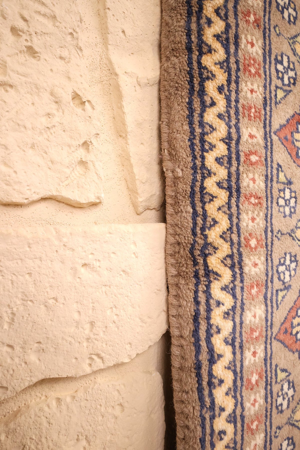 Lisière du tapis Karachi beige, bandes bleues et ligne ondulée écrue en bordure