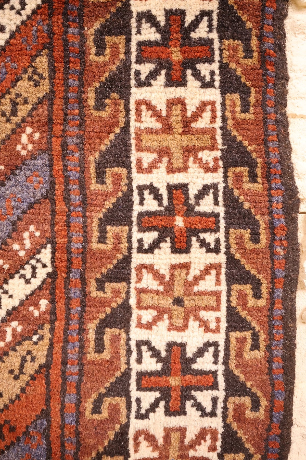Bordure ivoire du tapis, étoiles et croix à huit branches rouges et beiges