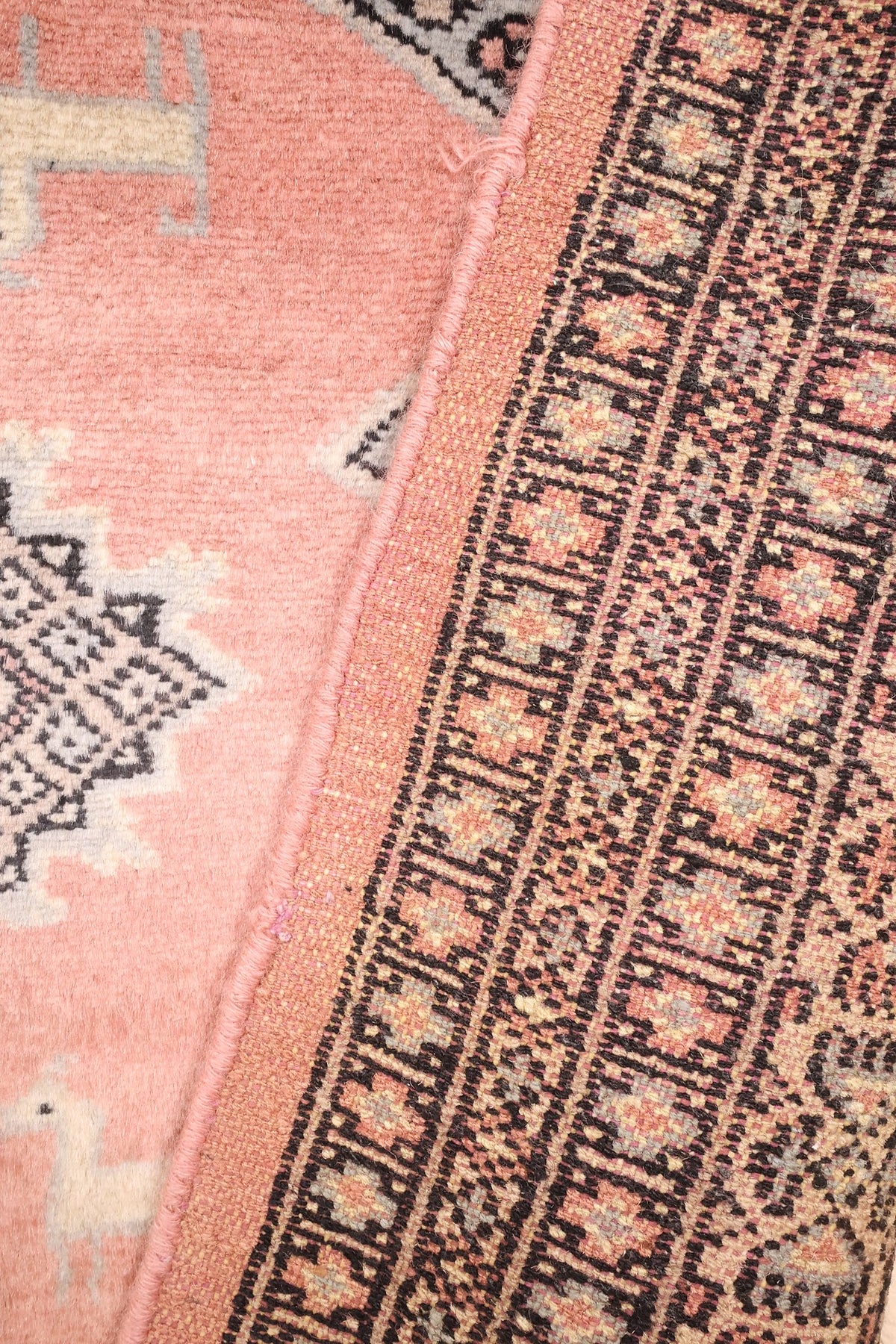 Tapis Boukhara rose, passage du champ à l'encadrement vu de près