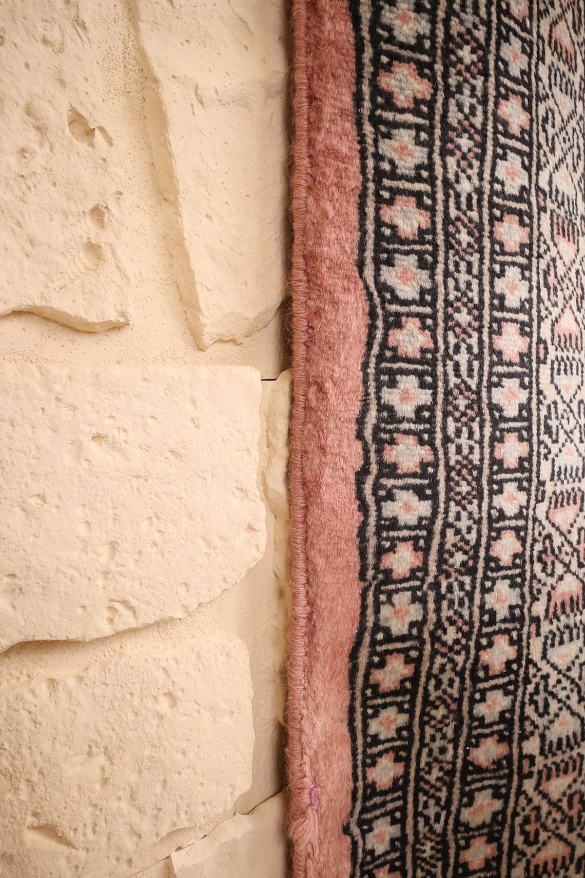 Lisière rose du tapis Boukhara le long des bordures à rosettes