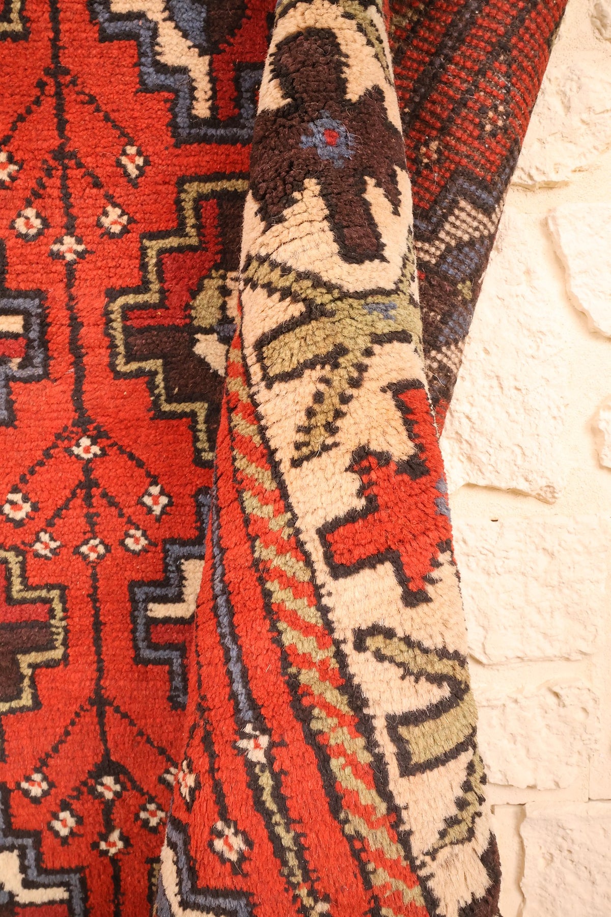Coin replié du tapis Karachi rouge, bordure et champ vus de près
