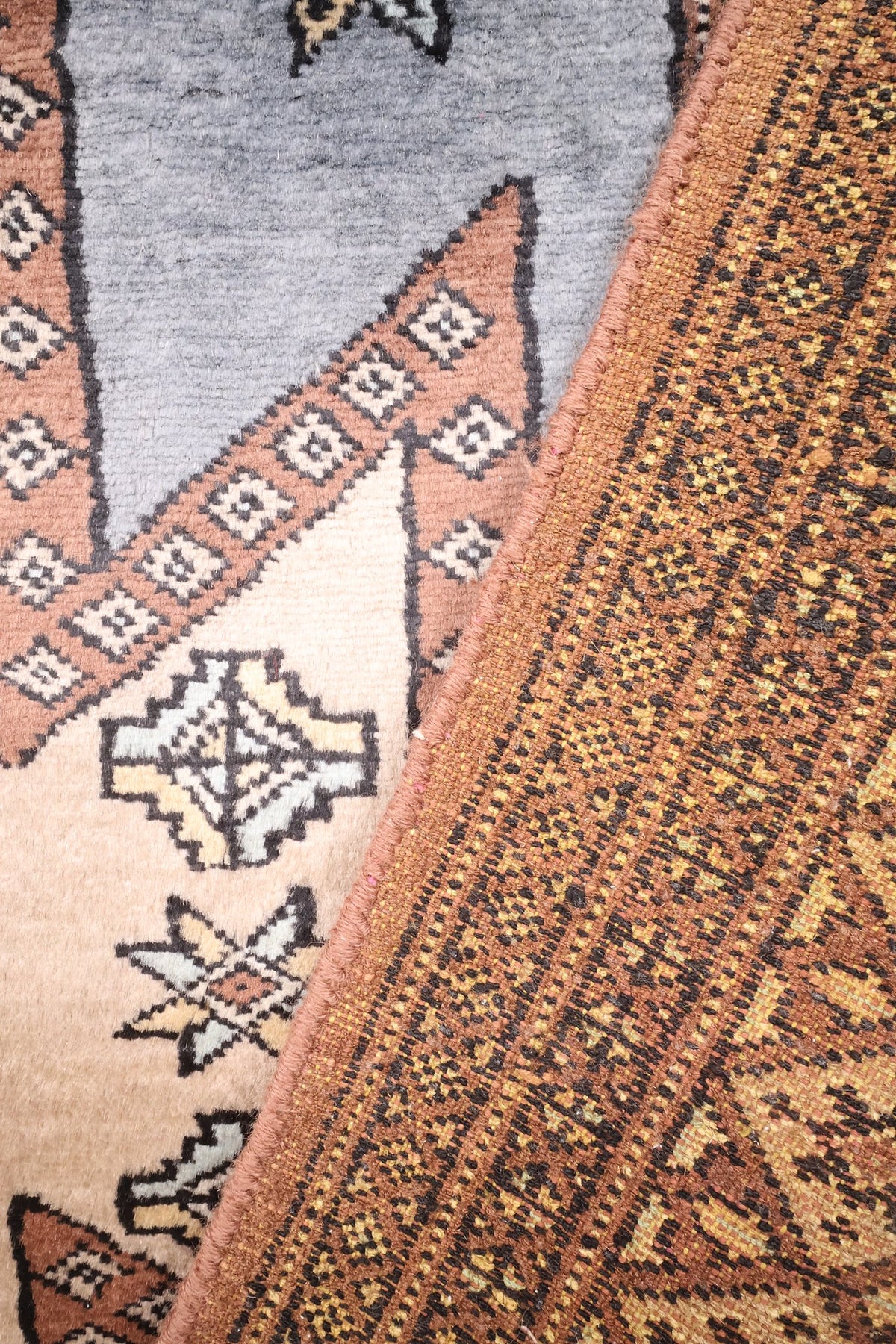 Coin replié du tapis Karachi gris, envers et motifs étoilés du champ