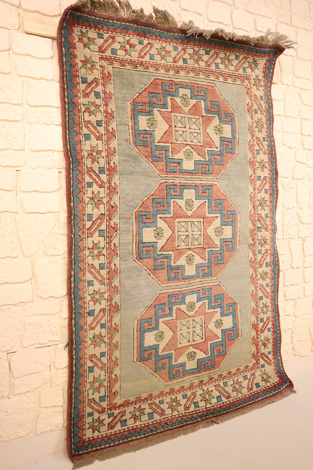 Tapis Kars en laine noué main, vue de biais montrant le champ bleu-gris et les franges