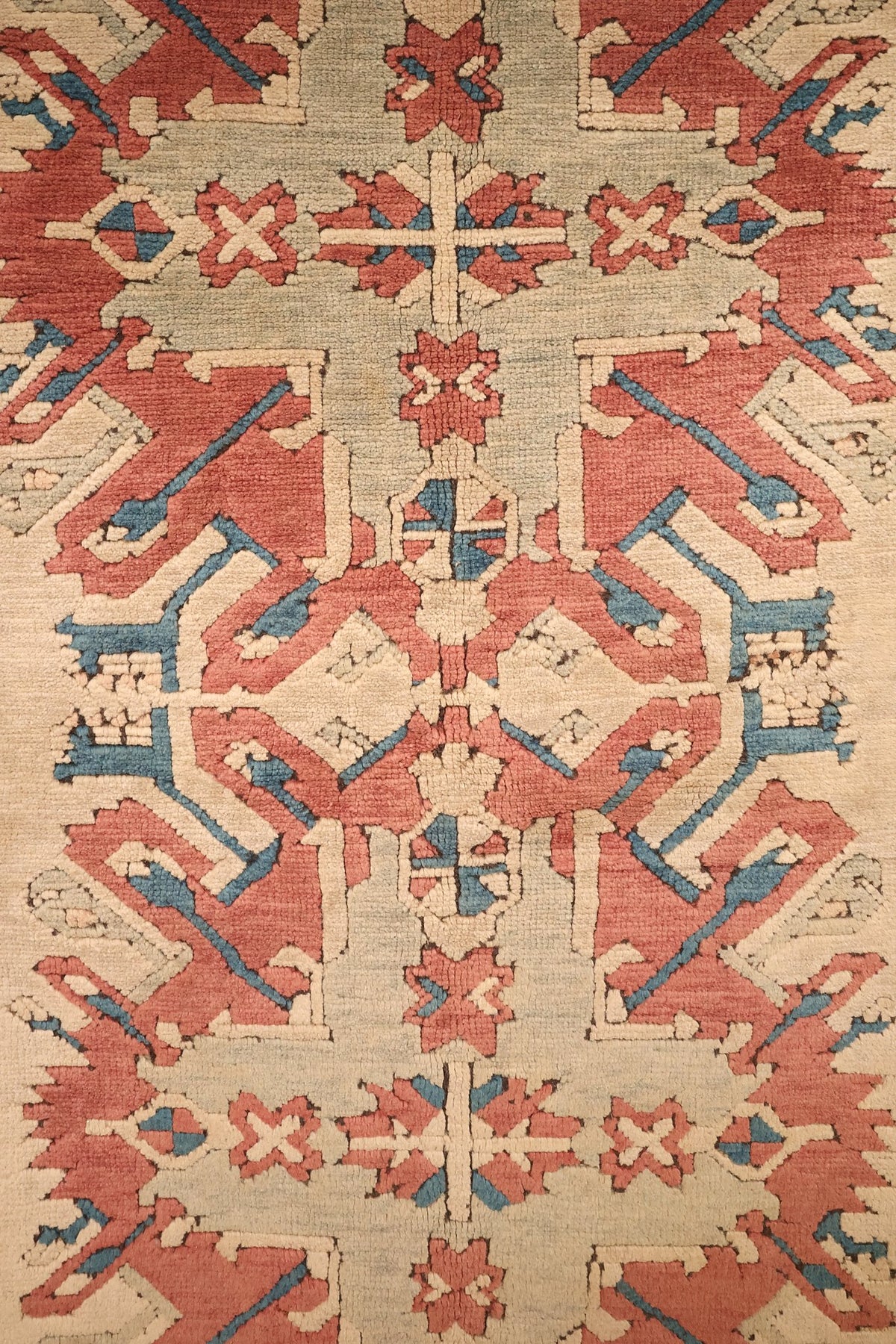 Détail des médaillons étoilés à crochets et accents bleus du tapis Kars rouge