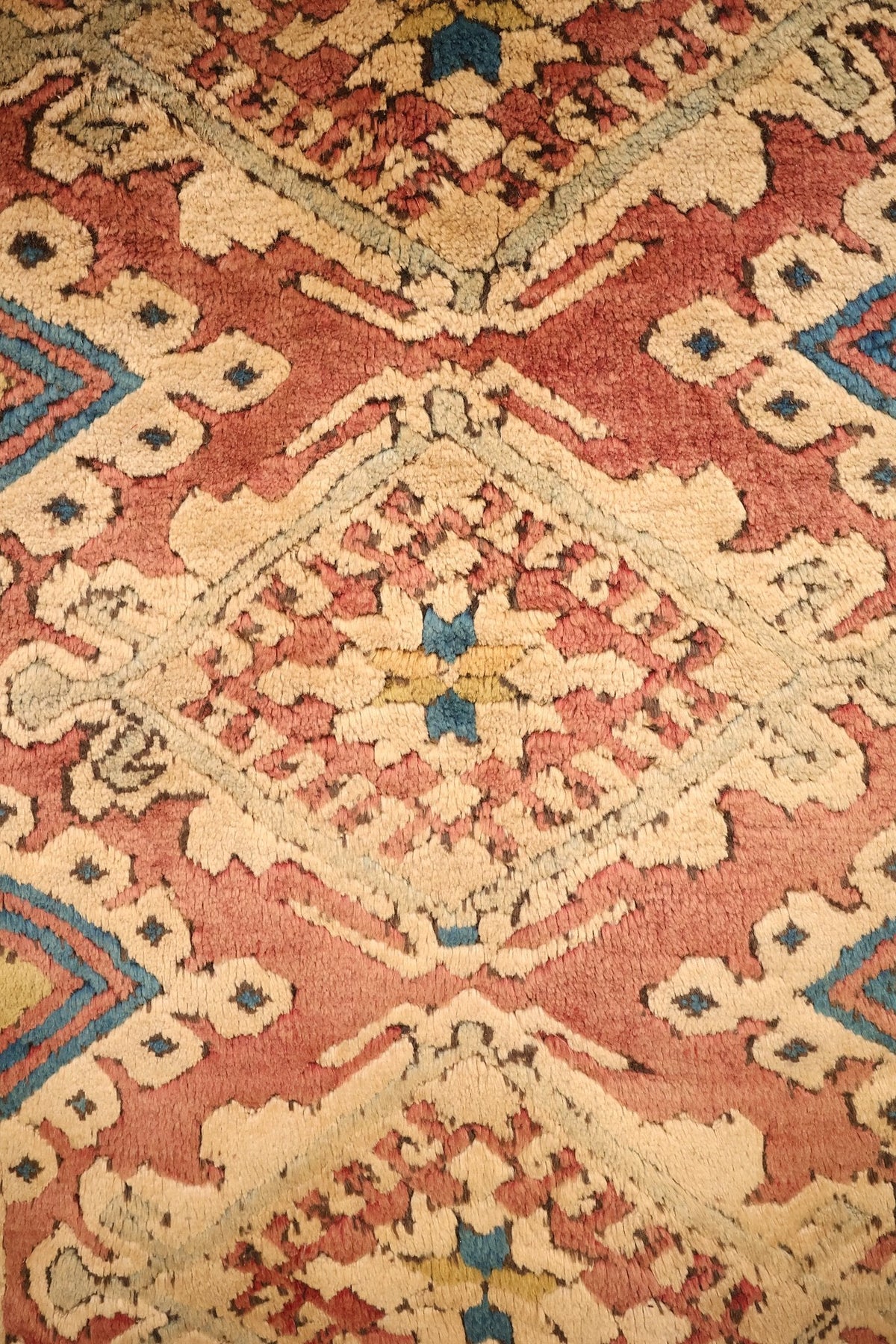 Détail du champ rose brique du tapis Kars, palmettes beiges et points bleus