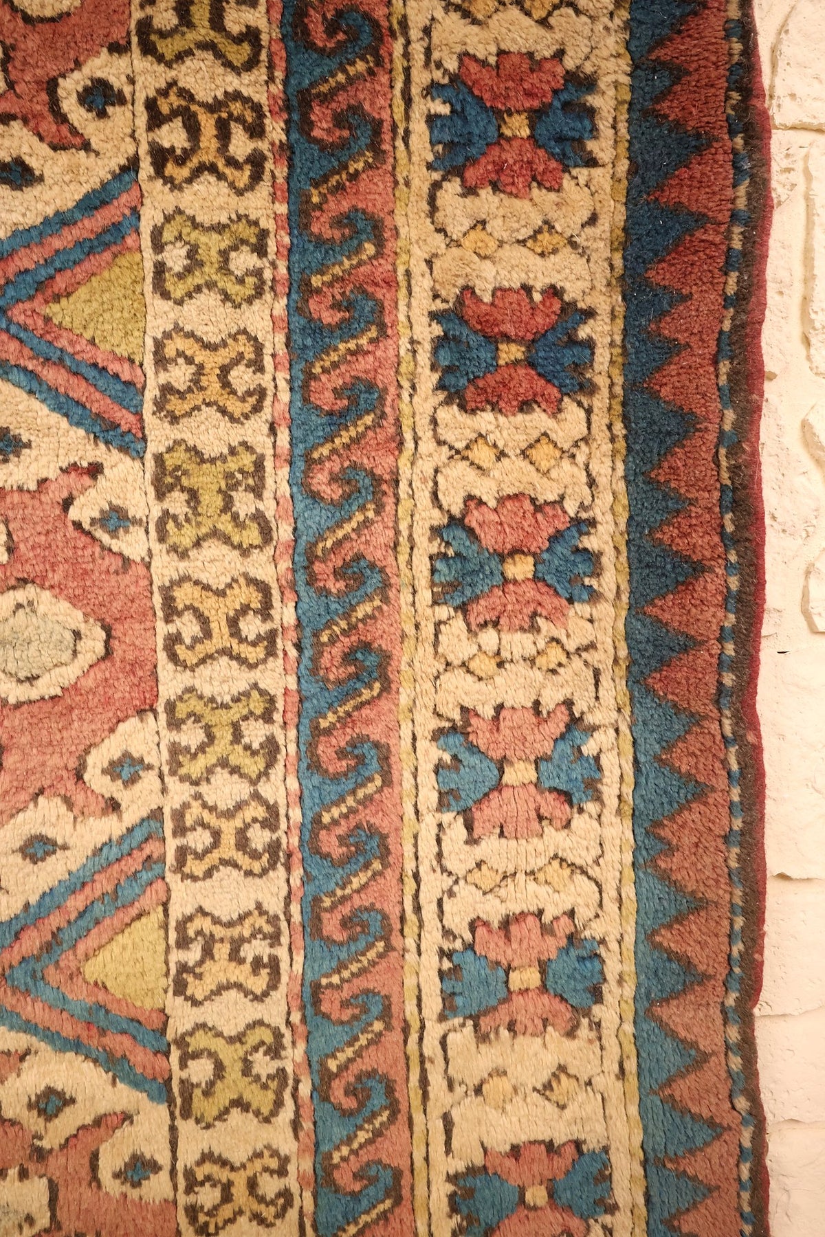 Bordure ivoire à fleurons bleus et roses du tapis Kars, galons à rinceaux