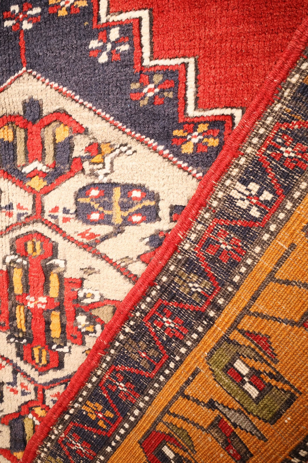 Coin du tapis Kars, champ rouge, écoinçon bleu et contre-bordure fleurie