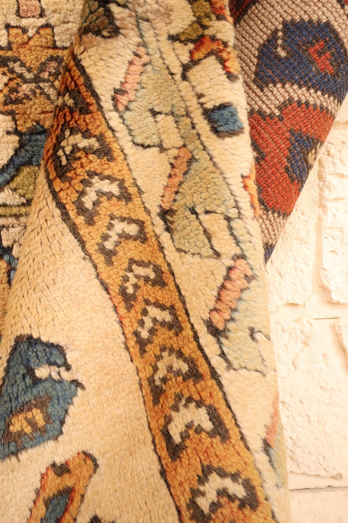 Coin replié du tapis Kars, contre-bordure orange à chevrons