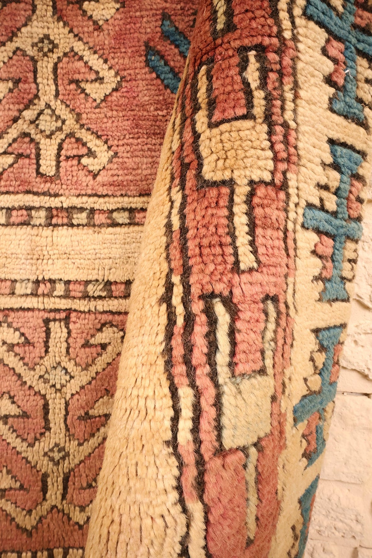 Coin retourné du tapis Kars beige et rose, bordure cruciforme bleue de près