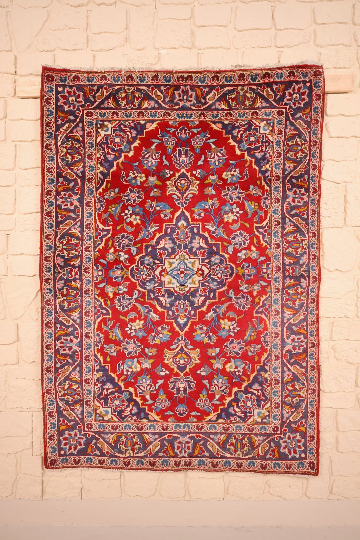 Tapis Kashan rouge 150 × 104 cm, vue d'ensemble du médaillon bleu-violet et des rinceaux fleuris