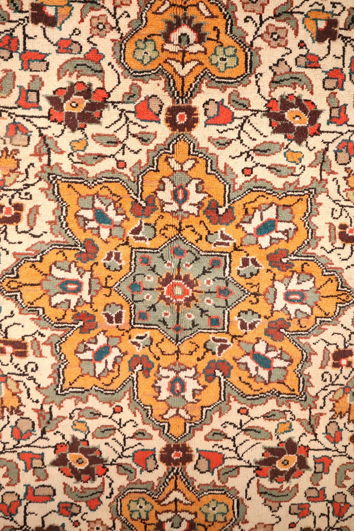 Détail du médaillon étoilé orange à cœur vert du tapis Kayseri, rinceaux fleuris